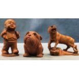 Three carved boxwood netsukes - tiger on rock, young boy walking, and dog, all signed with