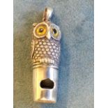 A sterling silver whistle modelled as an owl with inlaid glass eyes, having ring to head -
