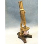 An Edwardian brass microscope on cast iron stand, unmarked and working. (10.25in)