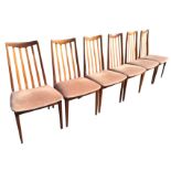 A set of six 60s teak G-Plan dining chairs with shaped lath backs above upholstered seats, raised on