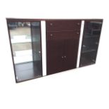 A contemporary faux walnut illuminated cabinet with glass doored mirrored shelves framing central