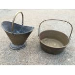 A Victorian brass helmet shaped coal skuttle with swing handle raised on circular base; and a