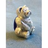 A 925 silver hallmarked seated teddy bear ,cast with pin cushion to back. (1.25in)