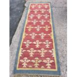 A hand knotted wool runner woven with tree style motifs on maroon field, framed by yellow & blue