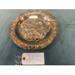 A circular Peruvian silver tray embossed with an aztec style rim and panel - the provenance