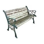 A rectangular slatted garden bench with scrolled cast iron ends raised on channeled sabre legs. (