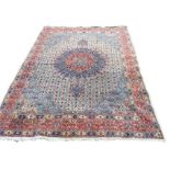 An Indian carpet woven with floral grid centered by blue floral medallion, having pale blue