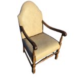 A small C20th stained armchair with arched back and shaped arms on turned spindles, raised on bobbin