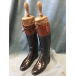 A pair of leather hunting boots with tan calf bands, having hardwood trees with turned handles and