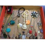 Fourty pendants on chains including some silver, polished stones, locket type, carved bone, horn,