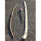 A traditional handmade 5ft 6in laminated hardwood archery longbow with leather grip, signed Legend