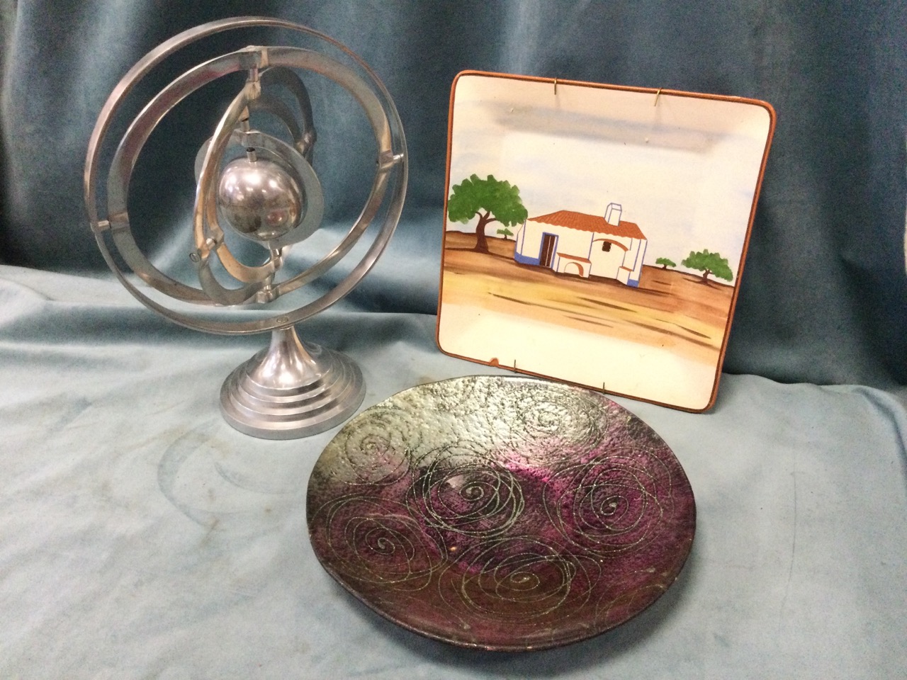 An aluminium armillary sphere on circular stepped stand; a square handpainted terracotta