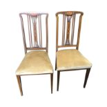 A pair of art nouveau mahogany side chairs inlaid with stringing, the back rails with oval walnut