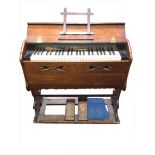 A Victorian mahogany cased portable harmonium, the instrument in decorative shaped case with pierced