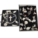 A charm bracelet with a total of 37 novelties, some on chain but mostly loose - medallions,