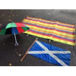 An umbrella shooting stick; a striped canvas beach windbreak, the four wood poles with metal tips;