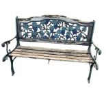 A cast iron garden bench, the arched back with pierced vine panel in hardwood frame, the slatted