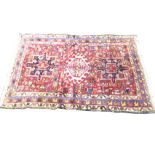 An antique Anatolian rug woven with central hooked medallion flanked by lozenges on busy leaf field,