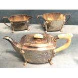 A hallmarked silver three-piece teaset with rectangular rounded bodies, raised on moulded legs to