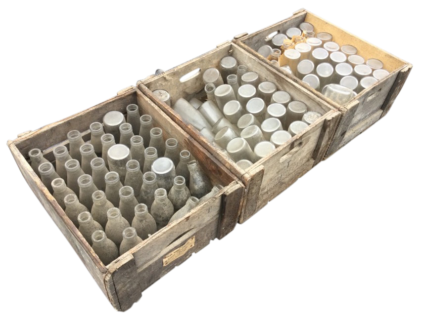 Three wood crates of old pint milk bottles, the boxes stencilled Rockware Glass Ltd, the bottles
