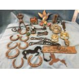 Miscellaneous metalware including four lionmask door knockers, a cast iron figure, horseshoes, pegs,