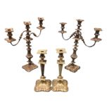 A pair of silver plated candelabra with leaf cast columns having foliate scrolled borders, each