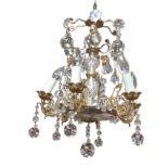 A glass & gilt metal chandelier hung from chain, having three tiers of glass drops around column,