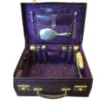 An Edwardian purple leather cased vanity dressing case with hallmarked silver brushes, bottles, shoe