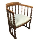 An Edwardian captains style armchair with rounded back on barleytwist supports, having cushion