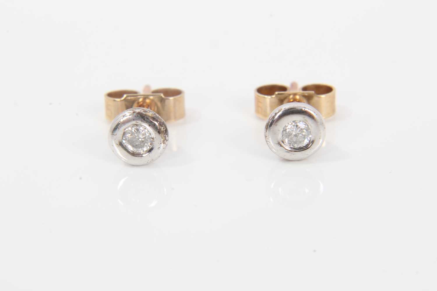Pair of diamond stud earrings, each with a round brilliant cut diamond weighing approximately 0.05ct