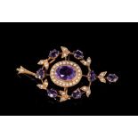 Edwardian amethyst and seed pearl pendant/brooch with a central oval cluster within a wreath design