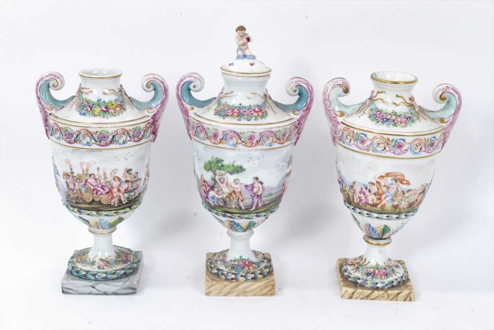 Good 19th century Capodimonte garniture of urns, decorated in relief with mythological scenes, on sq