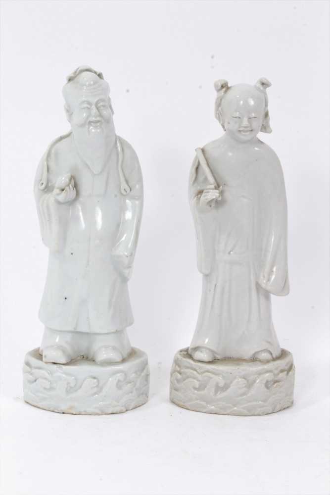 Good pair of antique Chinese Qing period blanc de chine figures, the female figure carrying a fly wh