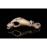 Regency gold and gem-set clasp in the form of a hand with textured finish, wearing a gem-set ring an