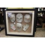 Group of four signed golf caps, two signed golf gloves and a signed golf ball, all mounted in a glaz