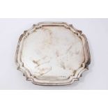 Silver salver of square form, with shaped corners on four bun feet (Sheffield 1933) by Viner’s Ltd.