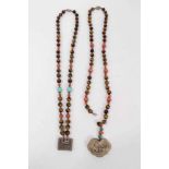 Two Chinese tiger's eye and coral bead necklaces with white metal panel pendants