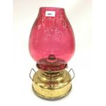 Early 20th century brass oil lamp with cranberry glass shade