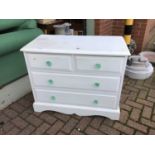 Painted pine chest of two short and two long drawers with shaped glass handles