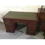 An early 20th century mahogany twin pedestal desk, with tooled green leather inset top and nine draw
