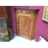 Georgian oak hanging corner cupboard with dentil cornice , panelled door enclosing three shaped shel