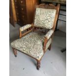 Pair of Edwardian carved oak his-and-hers chairs with padded backs, arms and seats on turned legs