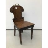 Regency mahogany hall chair, the arched panel back centred by recessed circular painted armorial cre