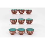 Set of nine Chinese Yixing pottery tea bowls, painted with calligraphy, enamelled blue inside and on