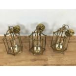 Set of three Georgian style brass hanging hall lanterns, each of hexagonal form with bowed glass hou
