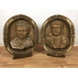 Pair of 20th century highly decorative carved wooden oval roundels depicting portrait busts of Roman