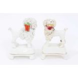 Two Staffordshire porcelain poodles with baskets, c.1840, highlighted in enamels and gilt, 9.5cm hei