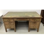 Early 20th century desk with an arrangement of seven drawers, leather lined top, on block legs, 153c
