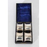 Set of four George V silver napkin rings of pinched form with egg and dart borders, (Birmingham 1913