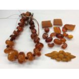 Amber bead necklace, loose beads and carved amber panel